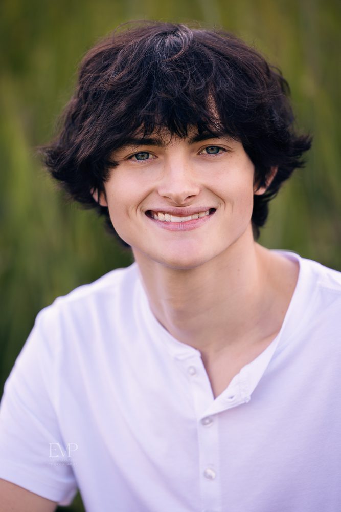 High school senior guy in white shirt smiling portrait