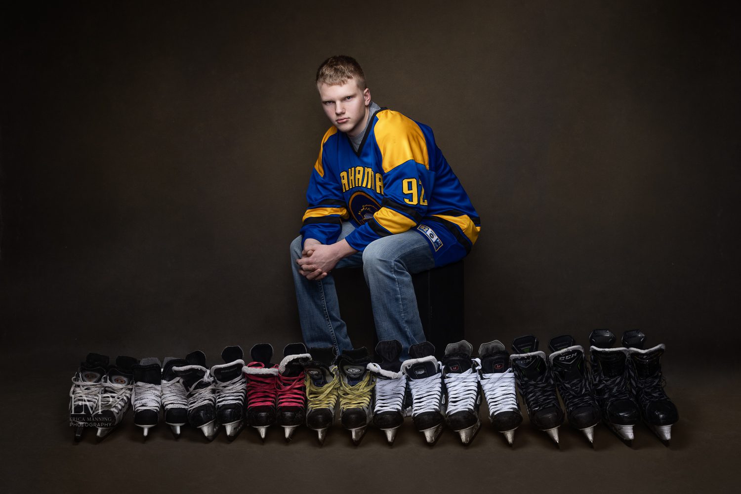 High school senior hockey player with all of his skates