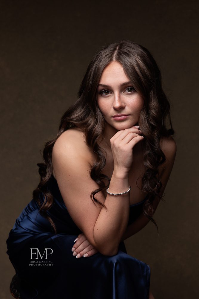 High school senior girl in formal dress in studio portrait