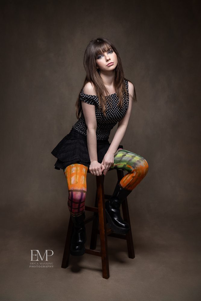High school senior girl with colorful tights in studio portrait